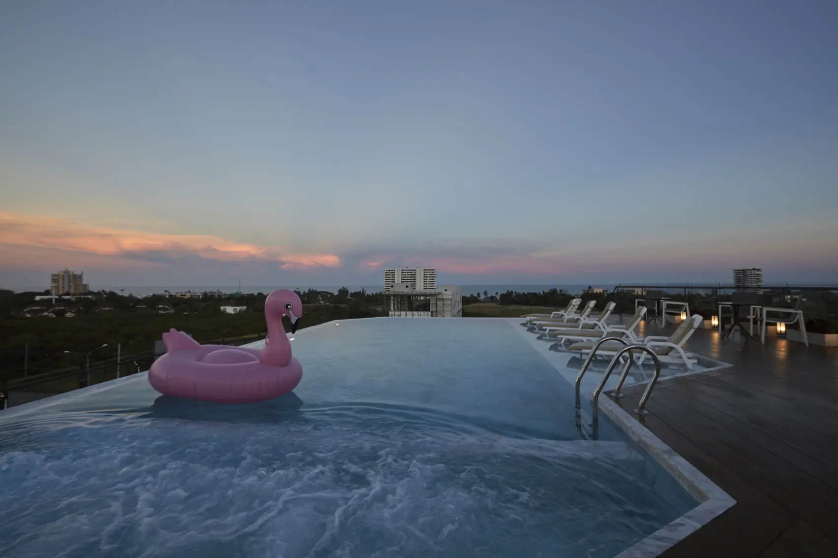 Rooftop pool at sunset and night