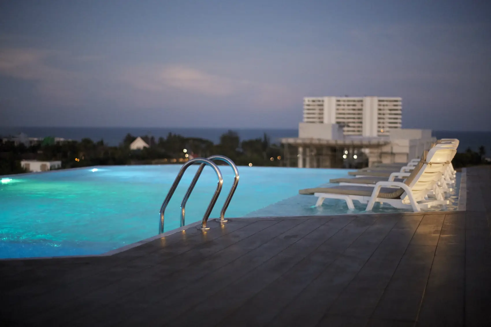 Rooftop pool at sunset and night