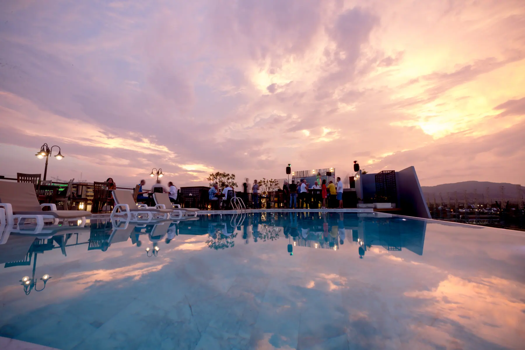Rooftop pool at sunset and night